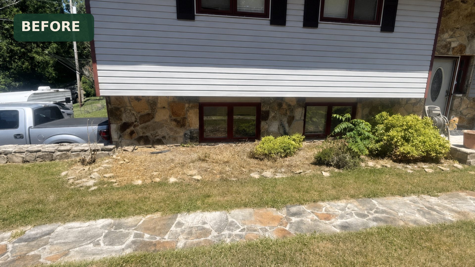 Wide before view of a split-level home in Chattanooga, TN with tired landscaping and weathered mulch beds