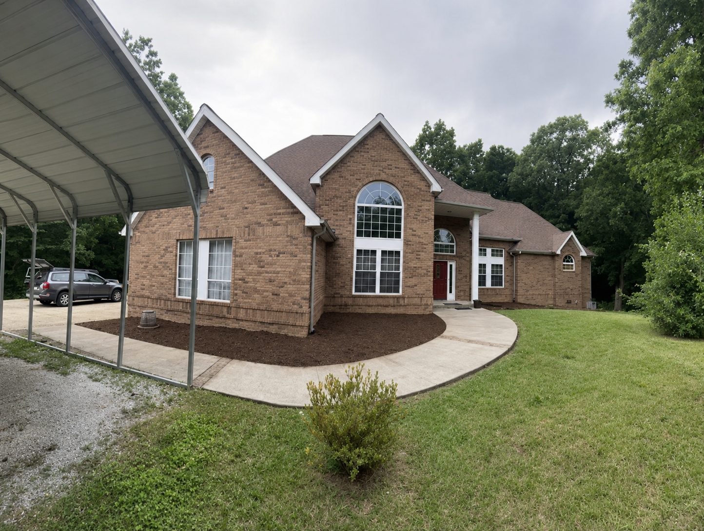 Angled view of a Chattanooga, TN split-level home showcasing clean bed edges, fresh mulch, and healthy lawn by LNK Ventures